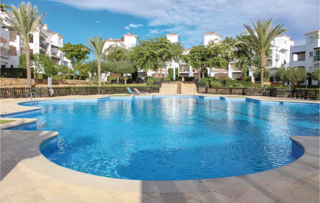 - une piscine d'eau bleue dans un complexe dans l'établissement Awesome Apartment In Roldan With Kitchen, à Roldán