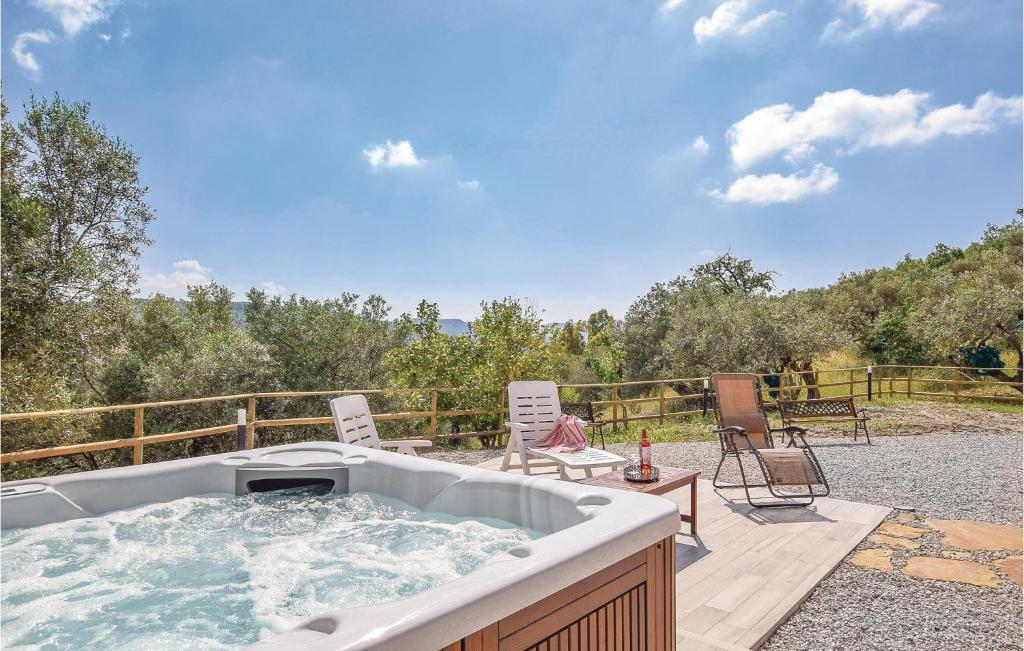 a hot tub sitting on a patio with chairs at Villa Aquaro in Ogliastro Cilento