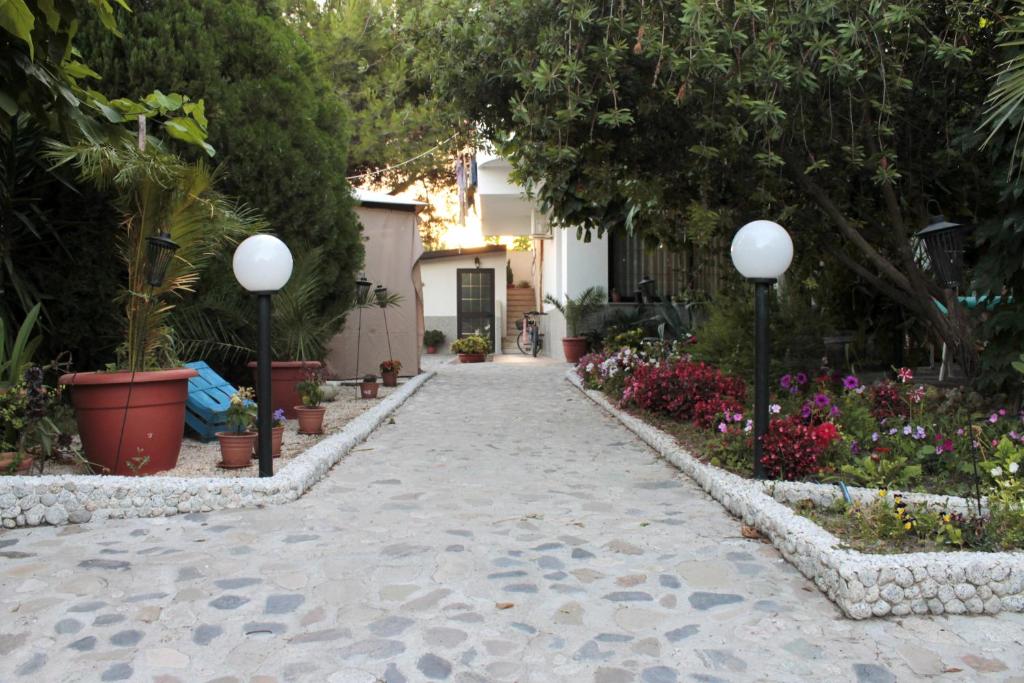 una pasarela en un jardín con flores y plantas en B&B Il Ristoro del Viandante, en Caulonia