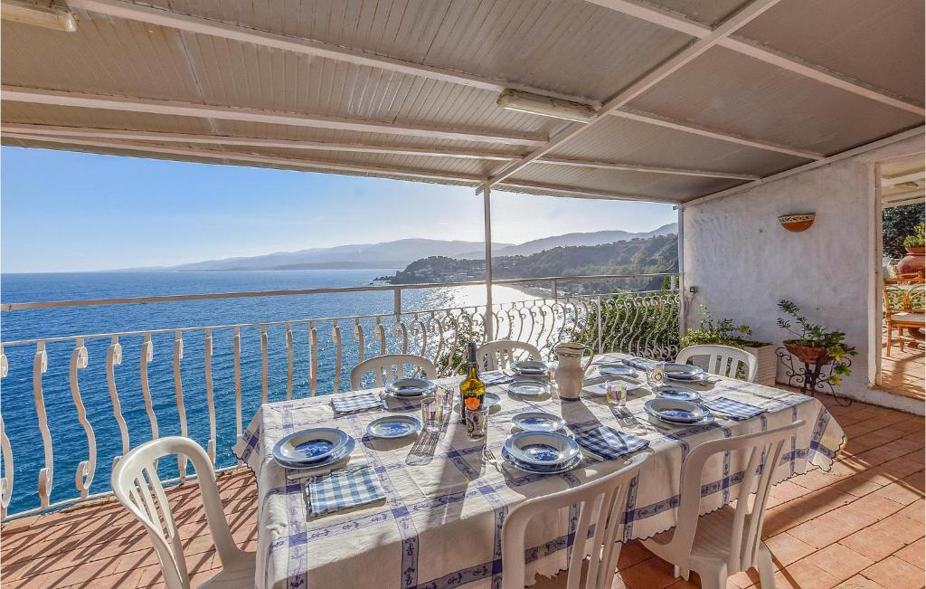 a table on a balcony with a view of the ocean at Villa Antica in Stalettì