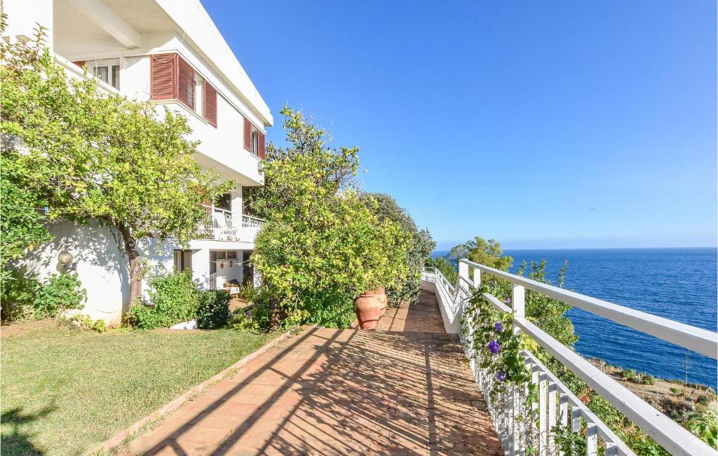 a white house with a balcony and the ocean at Villa Antica in Stalettì
