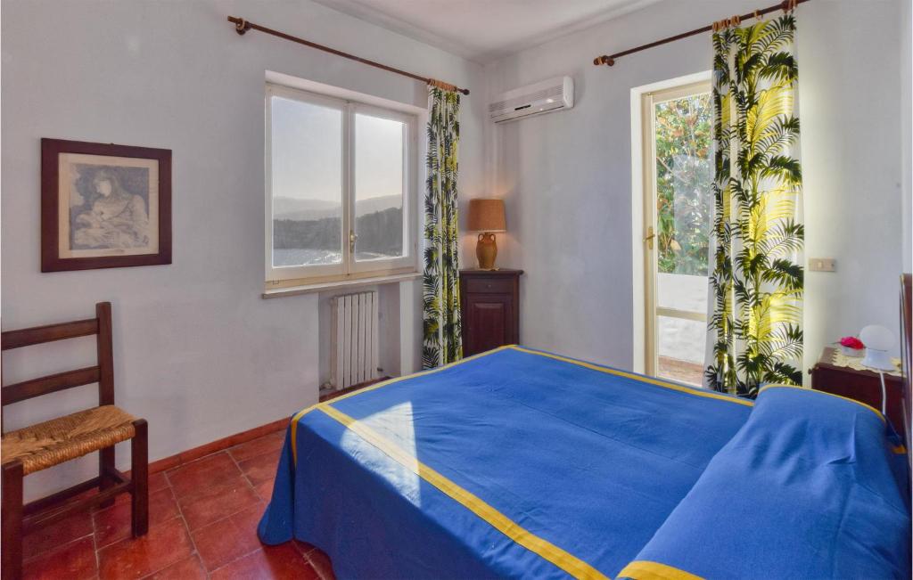 a bedroom with a blue bed and a window at Villa Antica in Stalettì