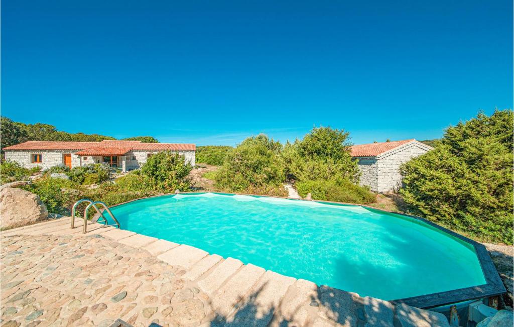a swimming pool in front of a house at Ginepri Bilo in Badesi