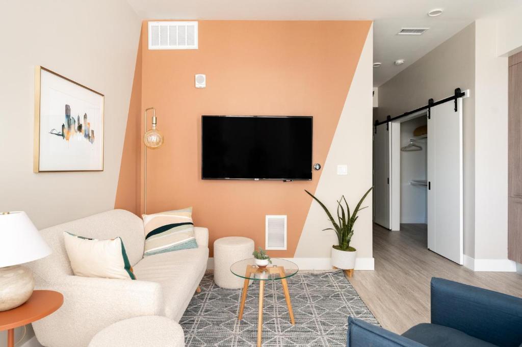 a living room with a couch and a tv on a wall at Colorful Western Vibe - Pet-Friendly - Zuni Lofts in Denver