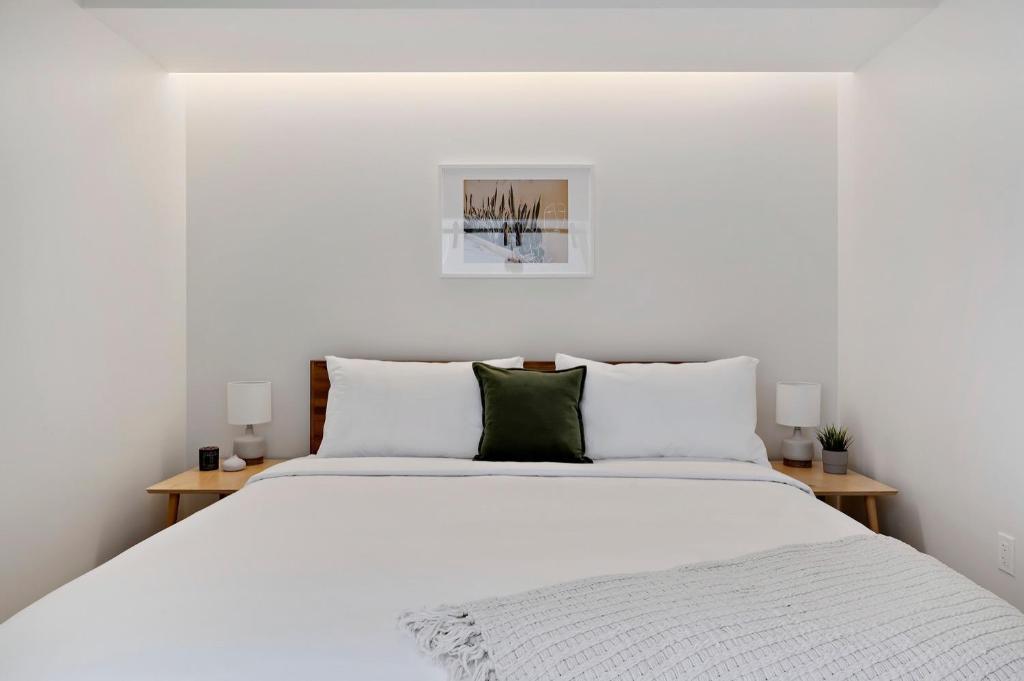 a white bedroom with a large bed with white pillows at Modern Lifestyle Loft with View - Zuni Lofts in Denver