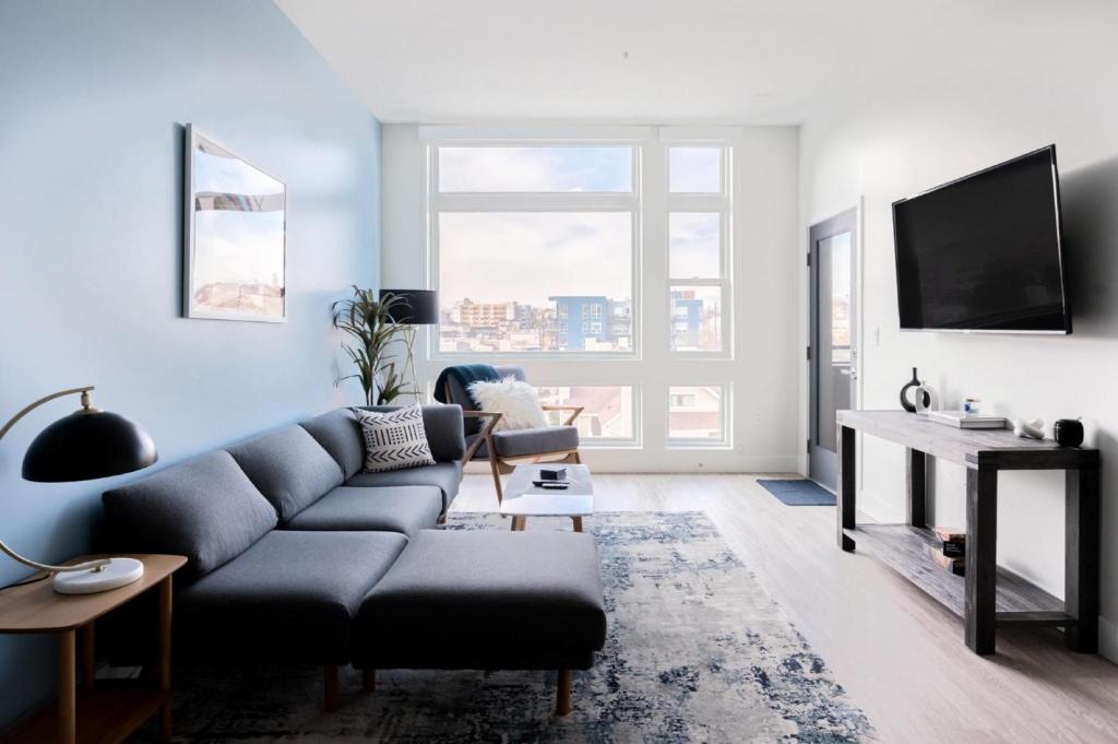 sala de estar con sofá y TV en City views - Luxe Loft - Zuni Lofts, en Denver