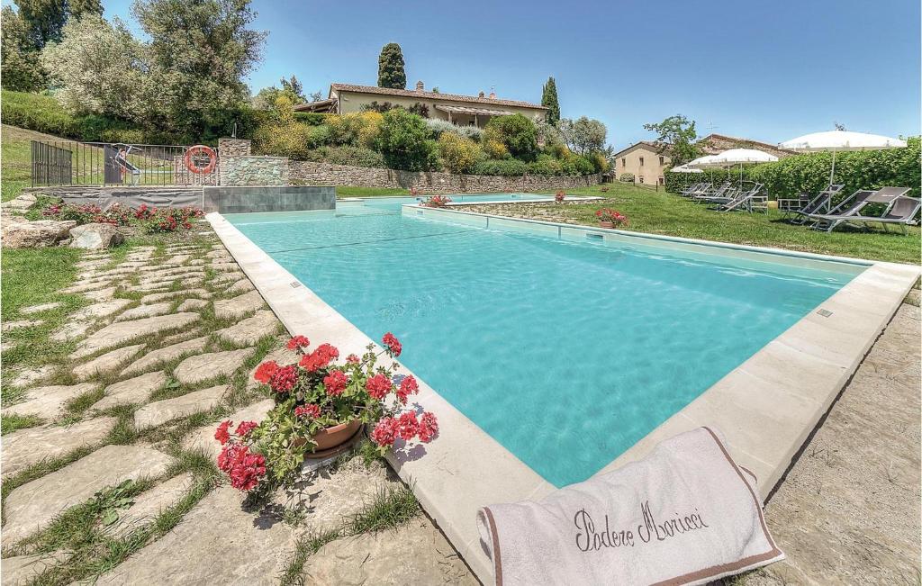 a swimming pool with flowers in a yard at Vincenzo-podere Moricci in Montaione