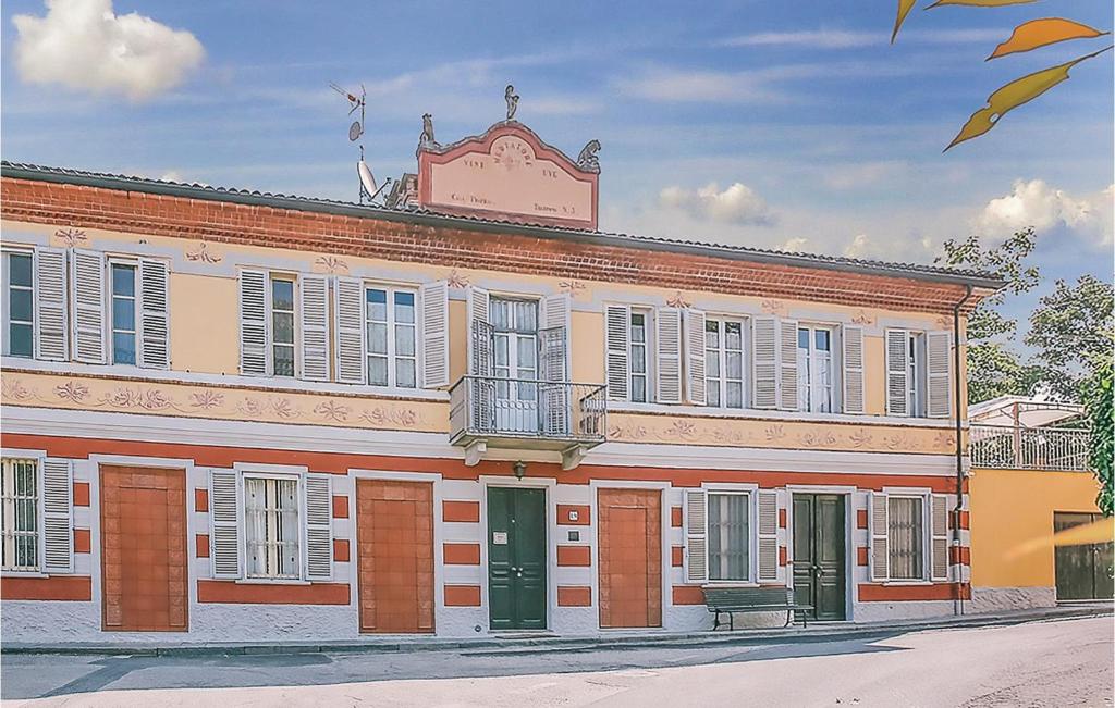 een groot bakstenen gebouw met ramen en een balkon bij La Locanda in Portacomaro