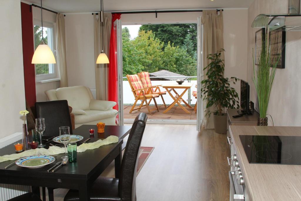 a kitchen and living room with a table and chairs at Ferienwohnungen In den Wiesen Oranienburg in Oranienburg