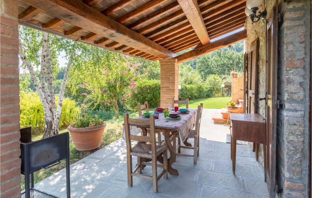 patio ze stołem i krzesłami pod drewnianym sufitem w obiekcie La Querciola w mieście Monte Castelli