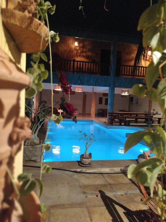 a large blue swimming pool at night at Pousada farol in Areia Branca