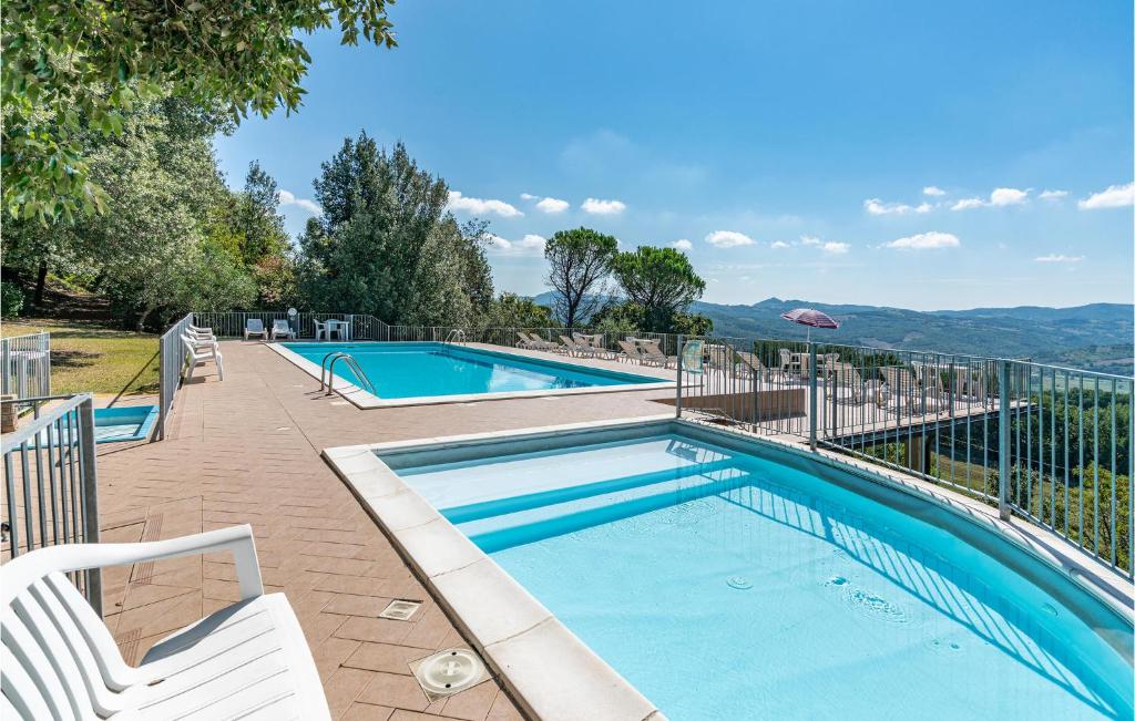 una piscina con 2 sillas blancas al lado en Ciliegio, en Citerna
