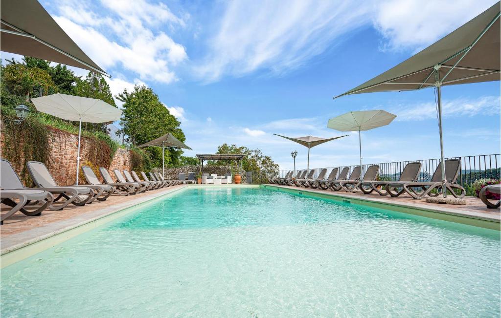 une grande piscine avec des chaises et des parasols dans l'établissement Flora House 2, à Macerino