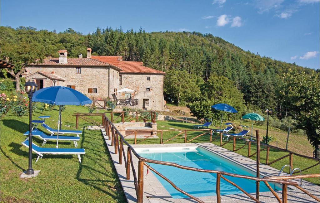 uma piscina com cadeiras e guarda-sóis ao lado de uma casa em Stunning Home In Cortona Ar With Wifi em Polvano