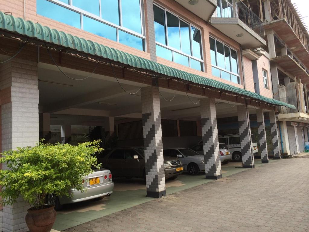 una fila de autos estacionados en un estacionamiento en Mc-Elly's Hotel, en Arusha