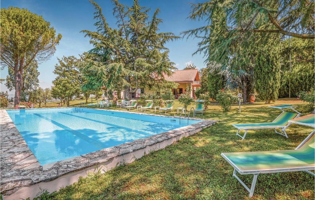 Montopoli in SabinaにあるAwesome Home In Montopoli Di Sabina Ri With Outdoor Swimming Poolの芝生の椅子と家のあるスイミングプール