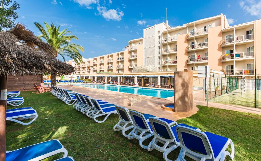 - une rangée de chaises longues au bord de la piscine d'un complexe dans l'établissement Globales Playa Santa Ponsa, à Santa Ponsa