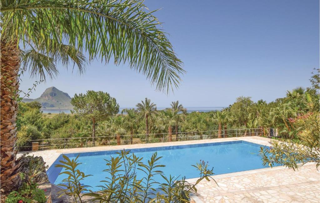 a swimming pool in a resort with a palm tree at Lovely Home In Makari-S Vito Lo Capo in Macari