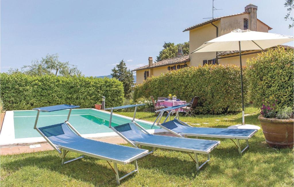 a group of chairs and an umbrella next to a pool at Tutignano in Pontassieve