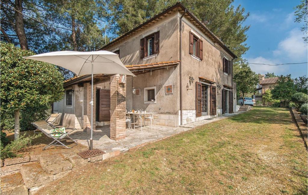 a house with an umbrella in front of it at Il Seminario in Collevecchio