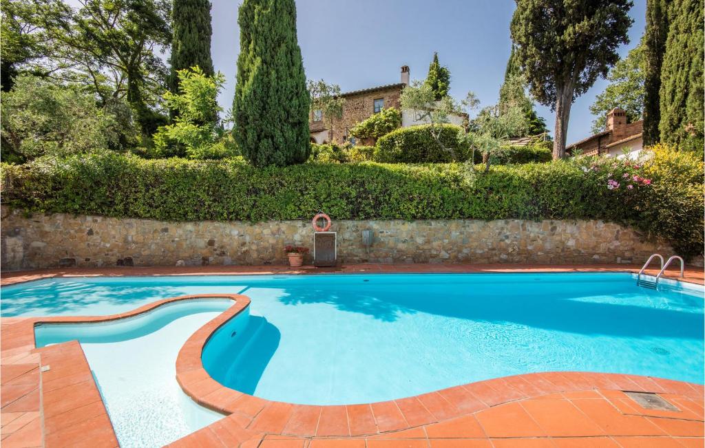 a swimming pool in a yard with a stone wall at Cherubini in Montaione