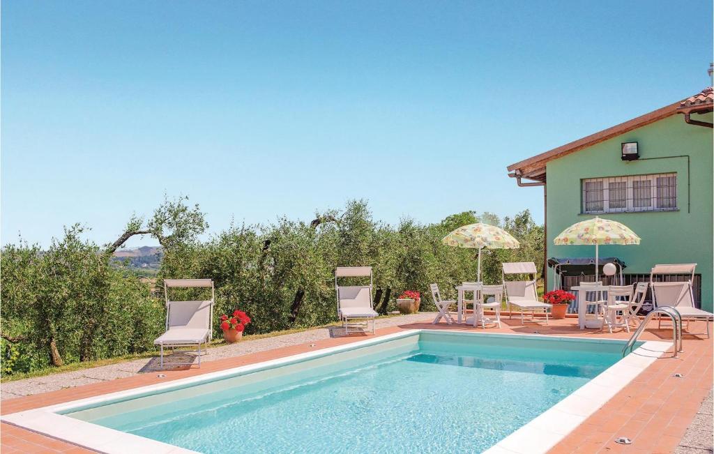 カステルフィオレンティーノにあるNice Home In Castelfiorentino -fi- With Outdoor Swimming Poolの家の隣のスイミングプール(椅子、パラソル付)