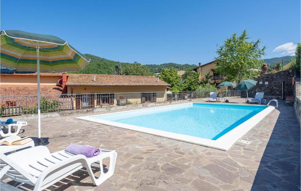 uma piscina com duas cadeiras e um guarda-sol em Il Moro em Villore
