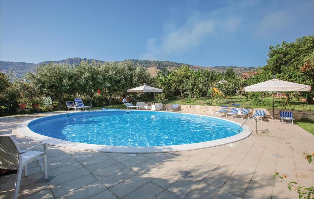 uma grande piscina com cadeiras e guarda-sóis em Villa Mare em Ioppolo