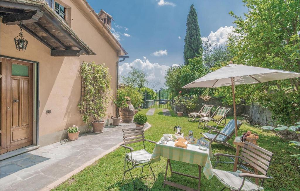 een tafel en stoelen met een parasol in de tuin bij Casa Lomi in Giampierone