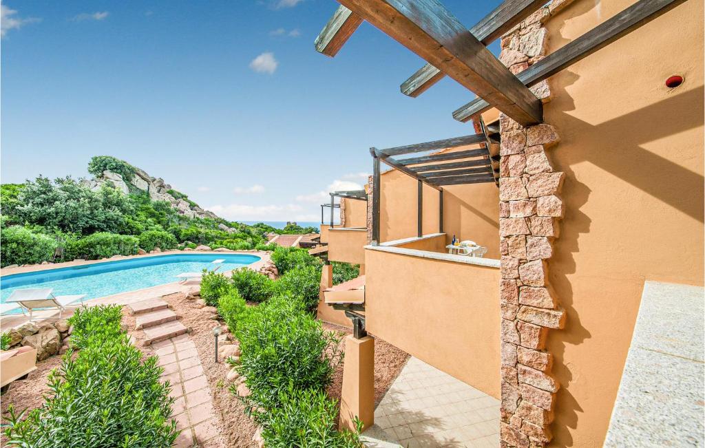einen Blick auf eine Villa mit einem Pool in der Unterkunft Cozy Apartment In Trinitadagultu Ot With Kitchenette in Trinità dʼAgultu