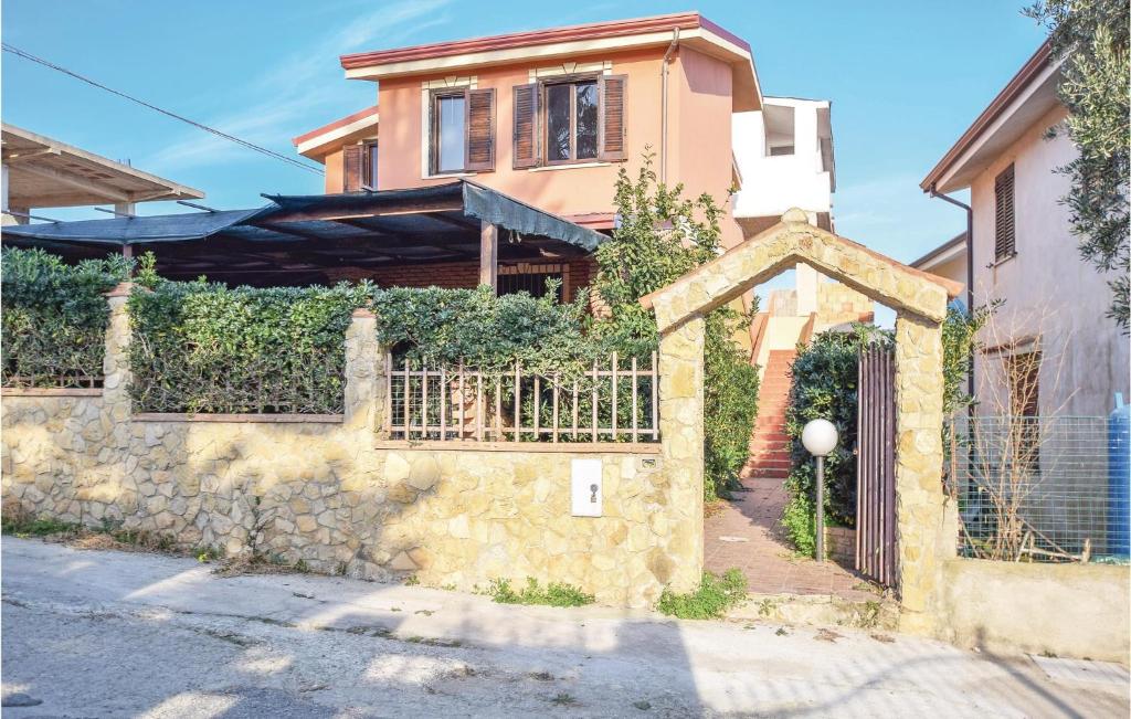 dom z bramą i kamienną ścianą w obiekcie Matteo Appartamento w mieście Ovile la Marinella