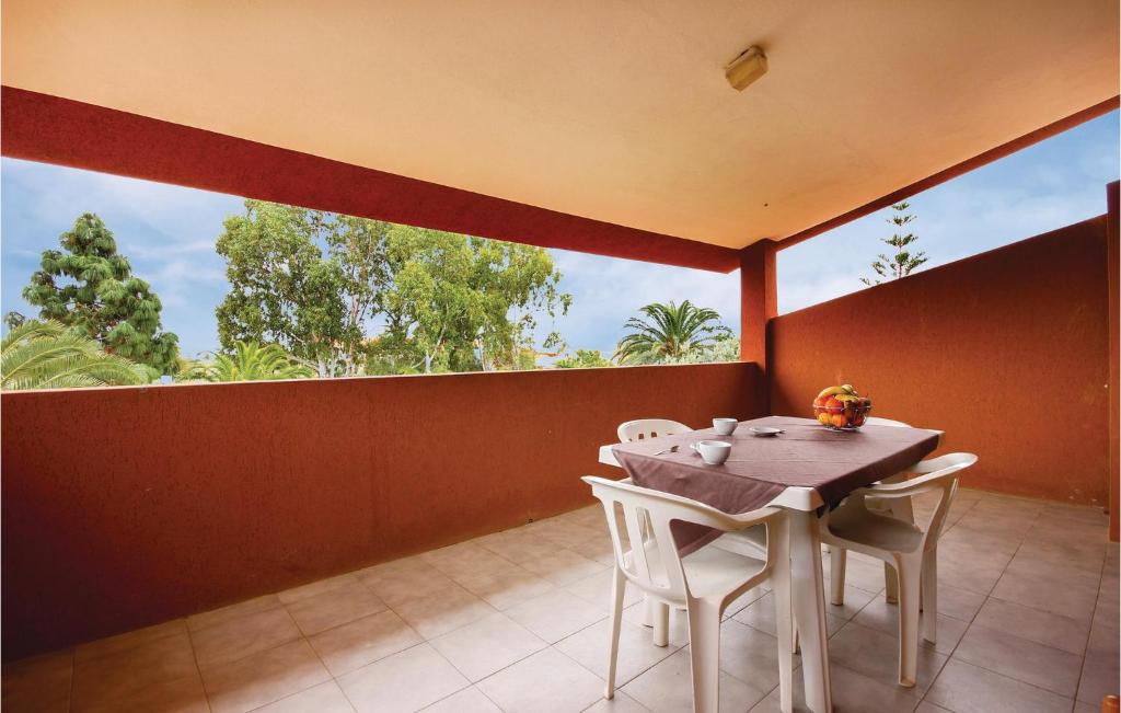 a dining room with a table and chairs on a balcony at Nice Apartment In Costa Rei -ca- With 1 Bedrooms And Wifi in Monte Nai