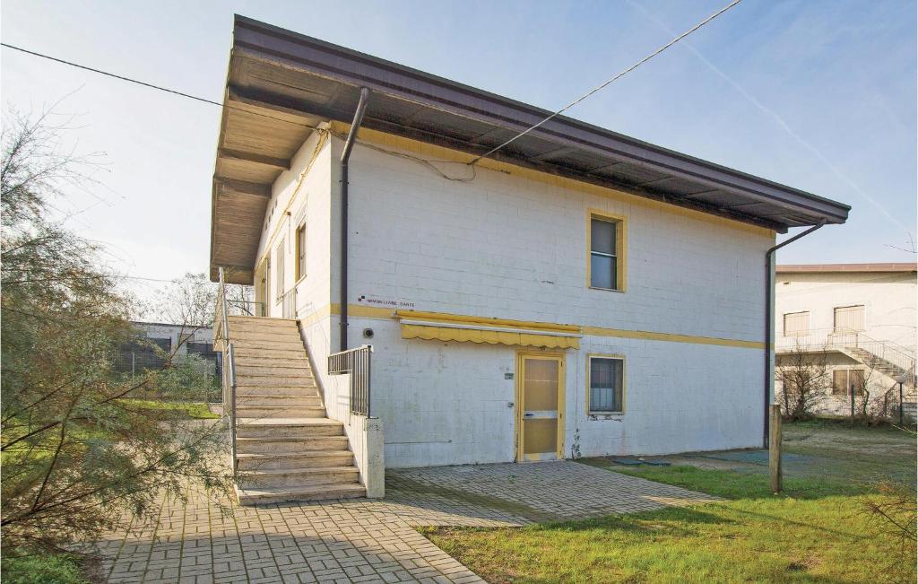 un bâtiment blanc avec un escalier sur son côté dans l'établissement Cagialla 4, à Rosolina Mare