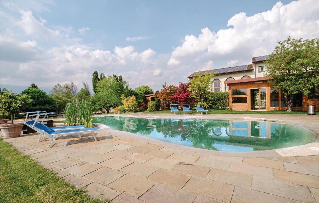 a swimming pool with a blue bench in front of a house at Stunning Apartment In Sacile -pd- With Swimming Pool in Sacile
