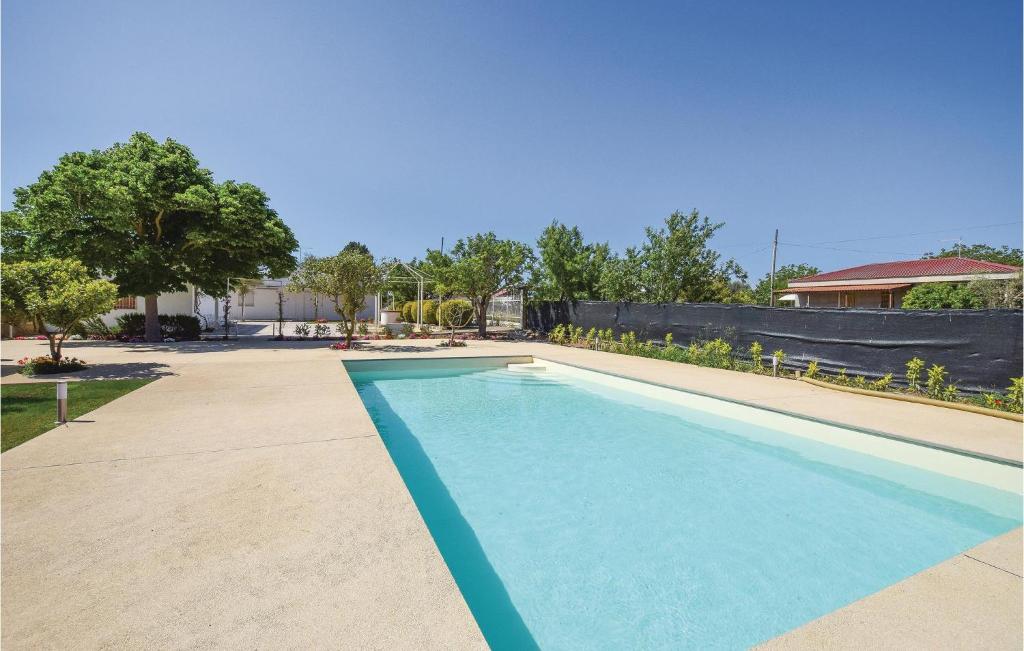 a swimming pool in a yard with a fence at Villa Ibiscus in Comiso