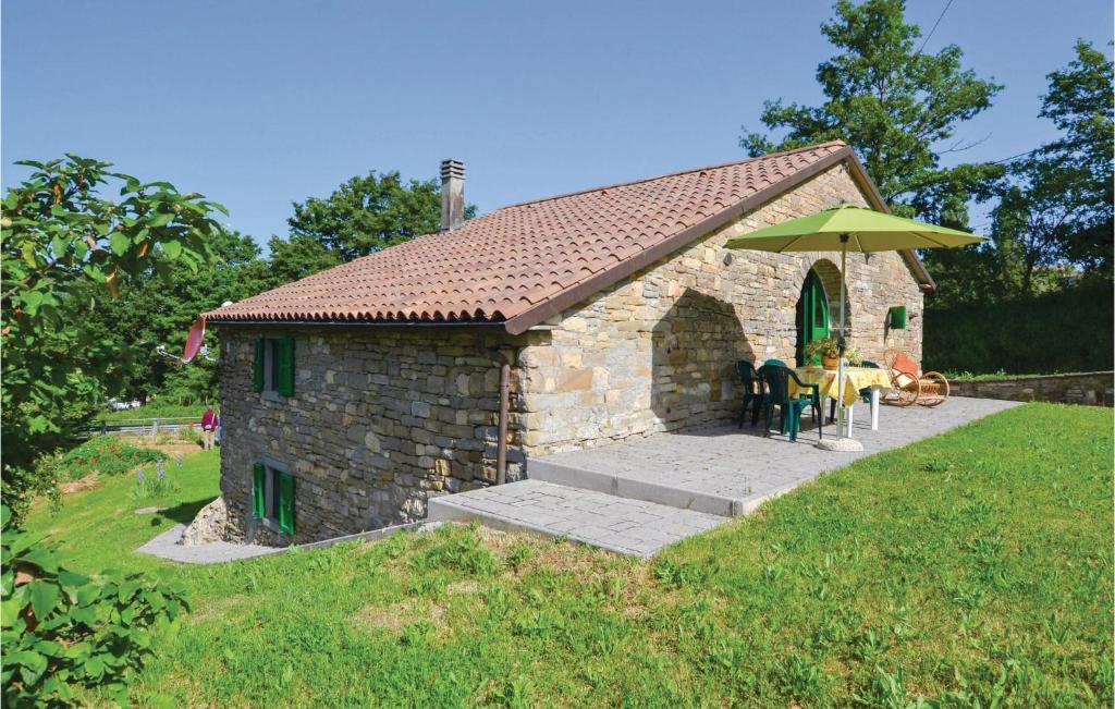 ein kleines Steingebäude mit einem Tisch und einem Sonnenschirm in der Unterkunft Il Fienile in Badia Tedalda
