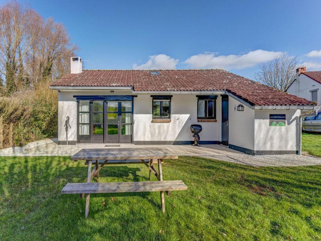 une maison avec une table de pique-nique devant elle dans l'établissement Inviting Holiday Home in Heuvelland with Garden, à Heuvelland