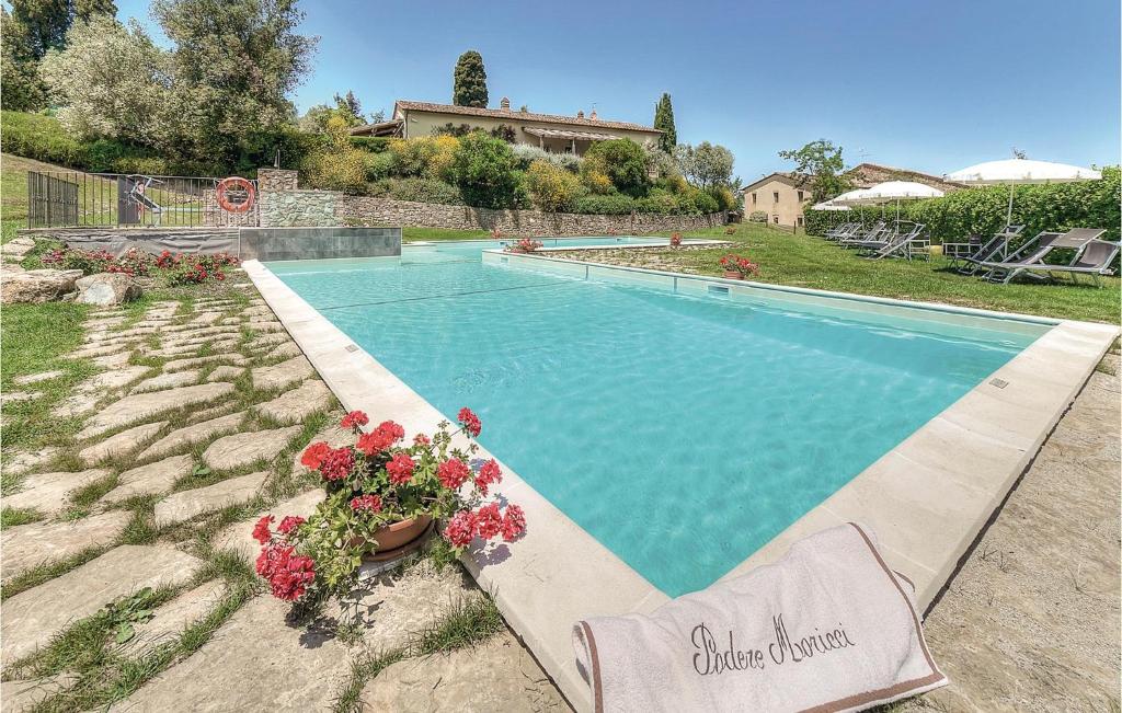 a swimming pool with flowers in a yard at Flaminia - Podere Moricci in Montaione