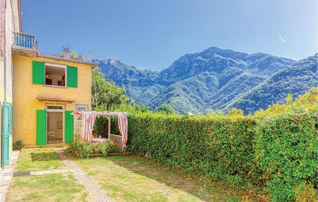 a house with a hedge and mountains in the background at Casa Tommasi in Stazzema
