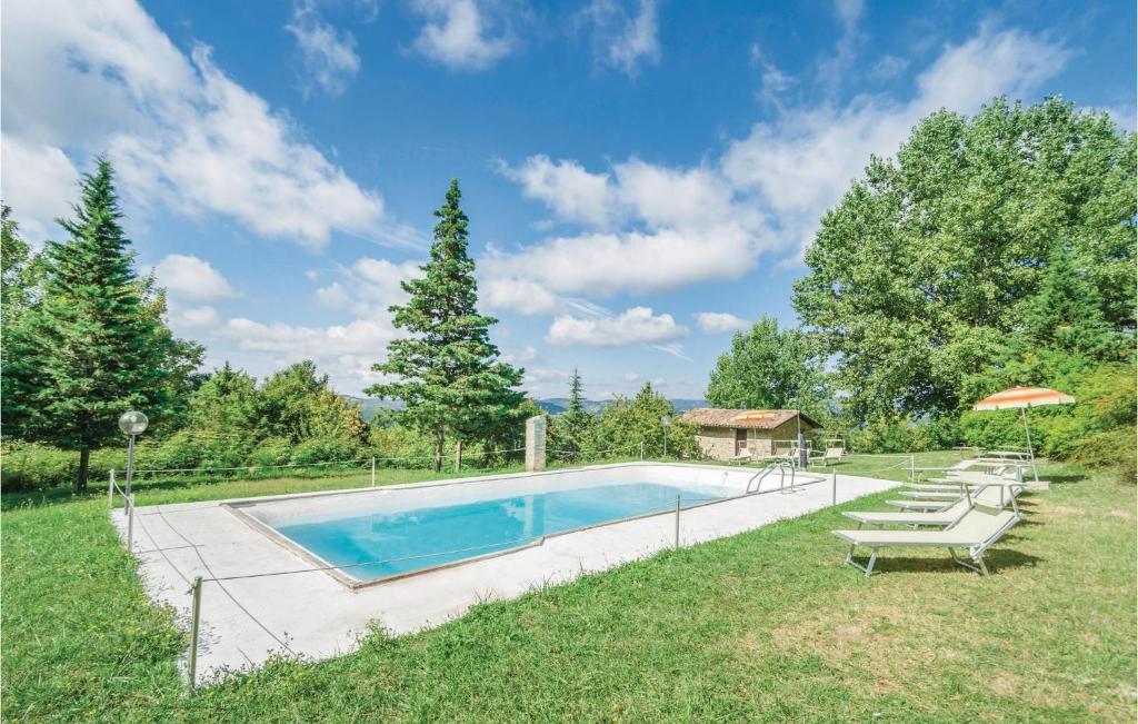 a swimming pool in a yard with chairs and an umbrella at Casellina in Apecchio