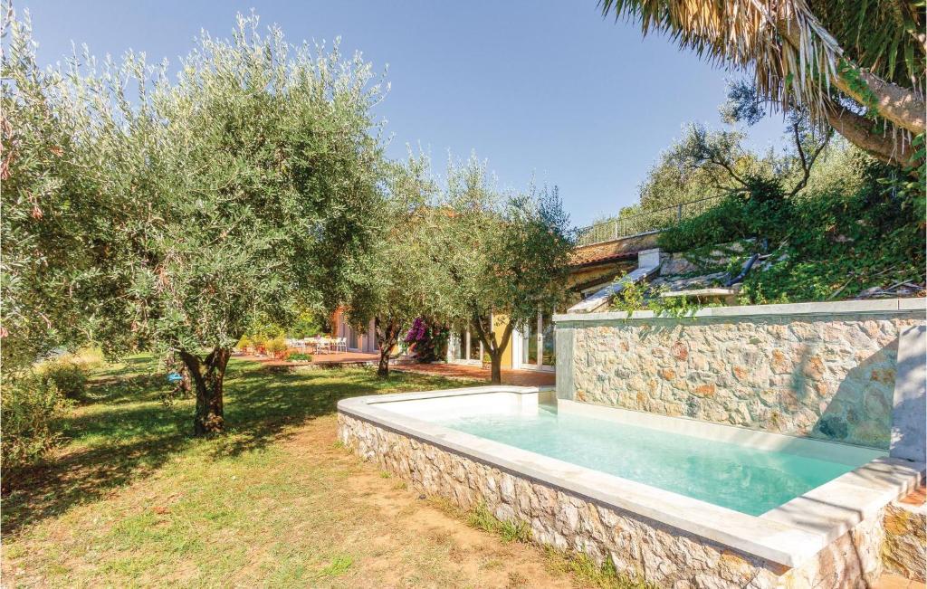 een zwembad in een stenen muur naast bomen bij Casa Emilia in Bergiola Foscalina