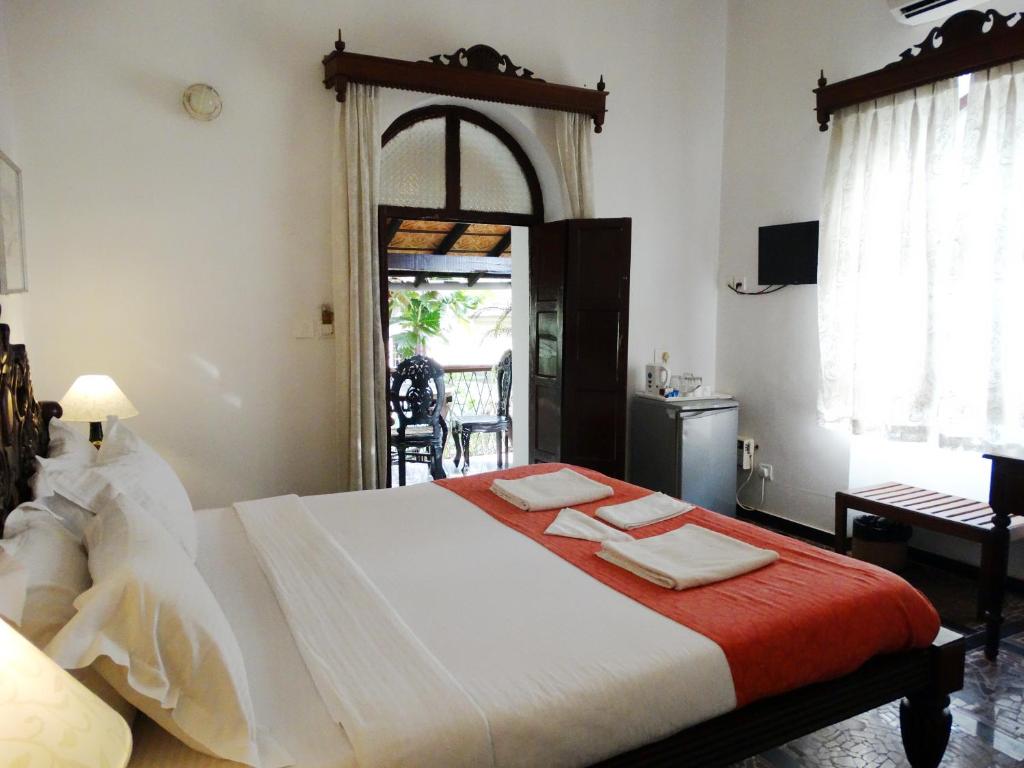 1 dormitorio con 1 cama grande y toallas. en WelcomHeritage Panjim Pousada, en Panaji