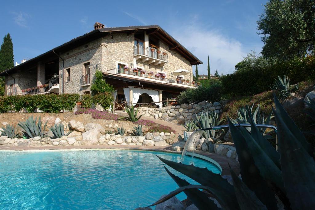 a house with a swimming pool in front of a house at Agriturismo Cascina Crocelle in Padenghe sul Garda