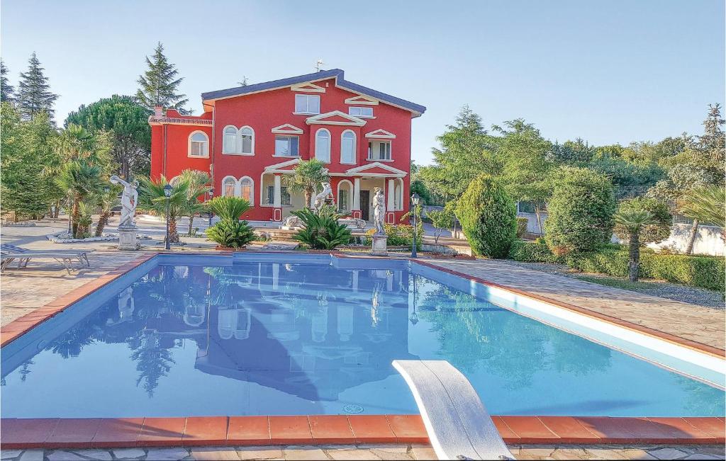 una grande casa con piscina di fronte a una casa di Villa Parco Del Monte a Cassano al Ionio