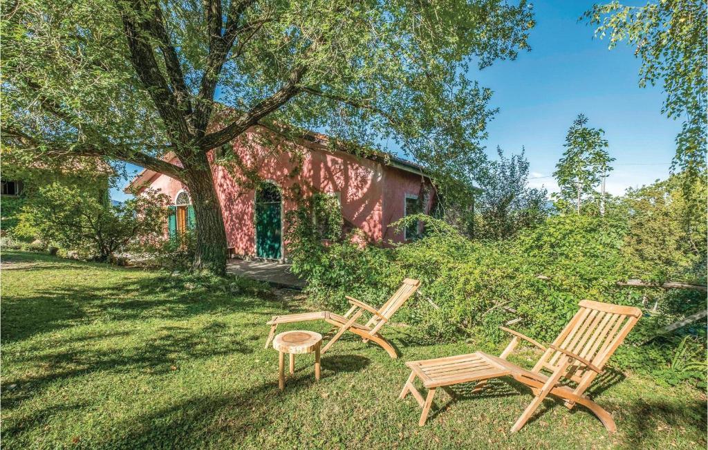 two wooden chairs and a stool in the yard at Casa Il Gumo in Varese Ligure