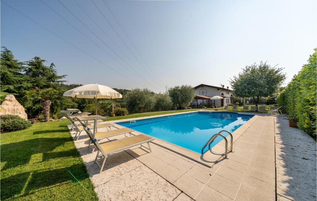 a swimming pool with a bench and an umbrella at Macchia Blu in Caprino Veronese