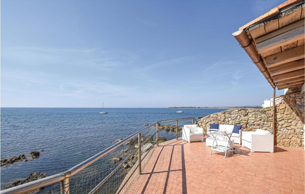een balkon met stoelen en uitzicht op het water bij Gorgeous Home In Tarquinia vt With Wifi in Tarquinia