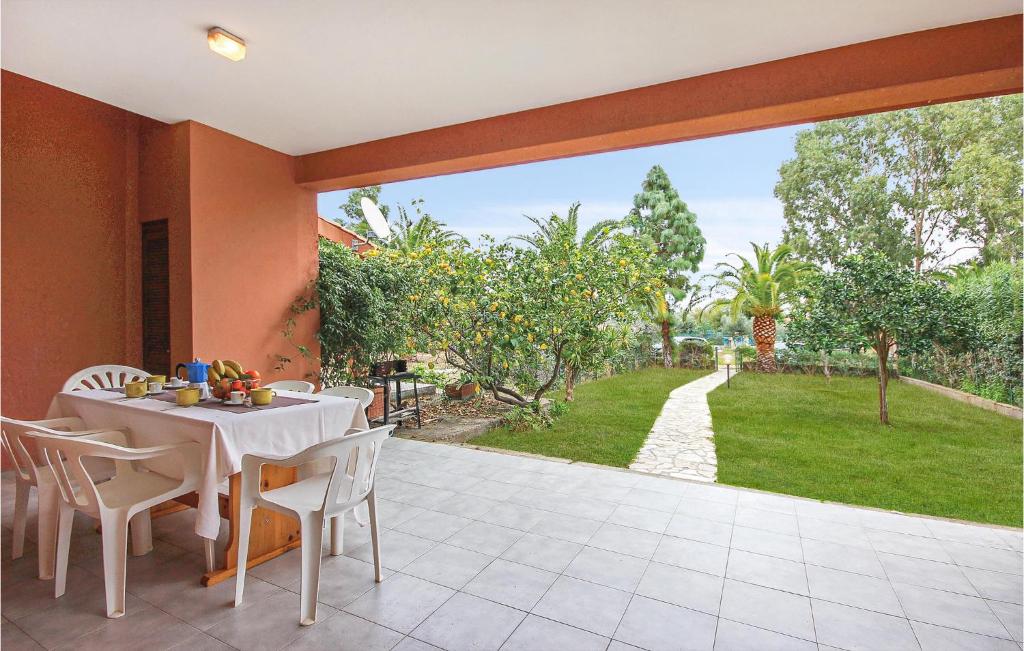 a dining room with a table and chairs on a patio at Lovely Apartment In Costa Rei -Ca- With Wifi in Monte Nai