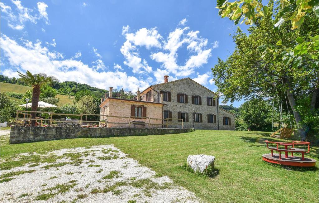 ein Haus mit einem Hof mit einer Bank davor in der Unterkunft Villa Genny in Cingoli