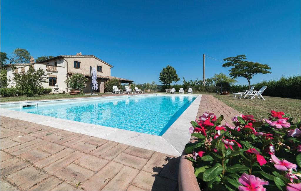 Monte CastelliにあるStunning Home In Citt Di Castello Pg With Wifi, Private Swimming Pool And Outdoor Swimming Poolのピンクの花が咲く家の前のスイミングプール
